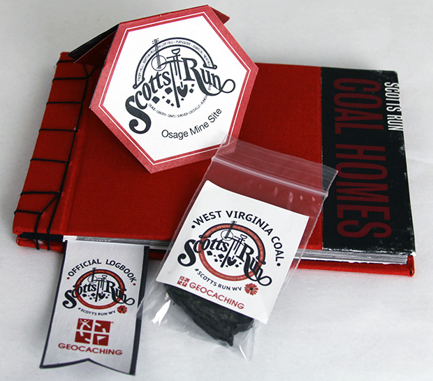 Inside Geocache for Scott's Run that includes a log book, instructions and a takeaway coal packet